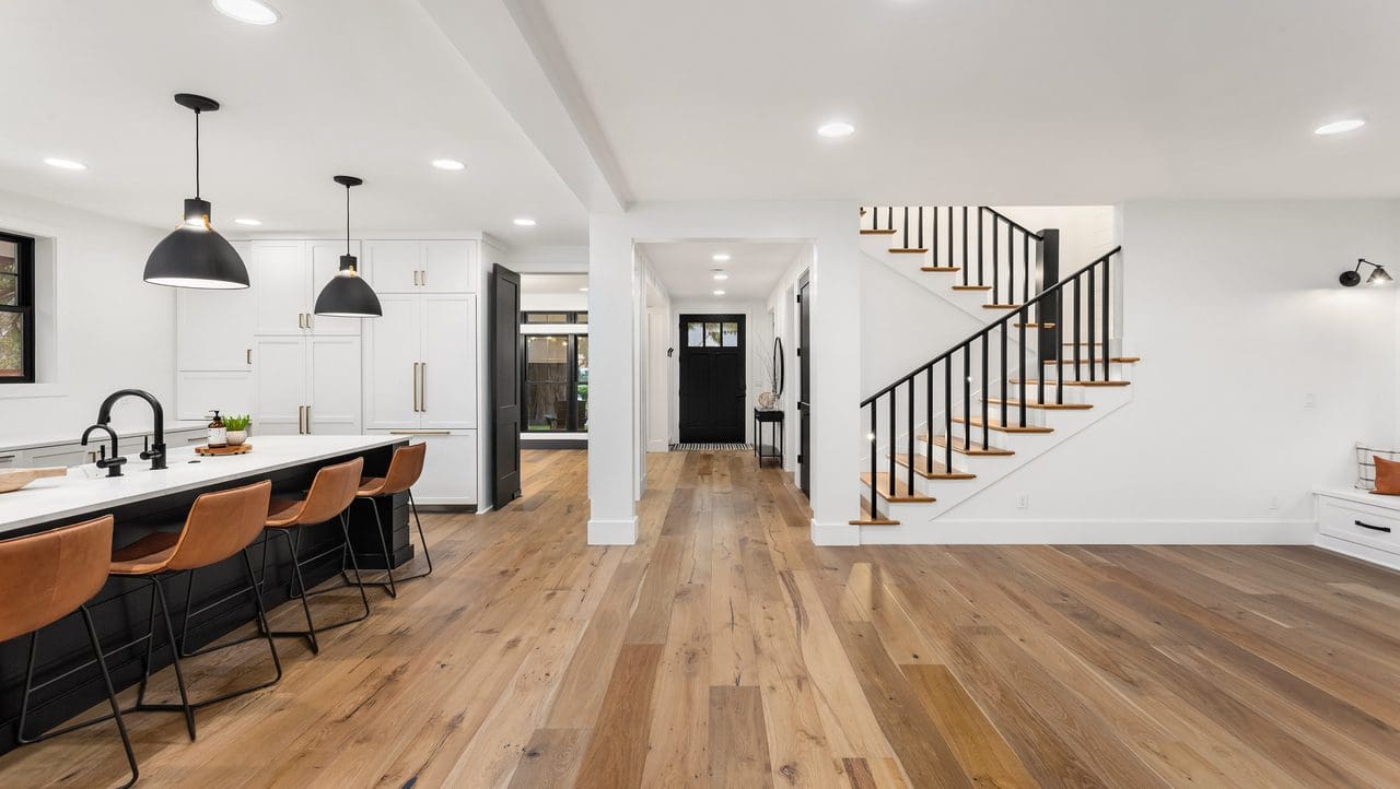 A room with wooden floors and stairs leading to the second floor.