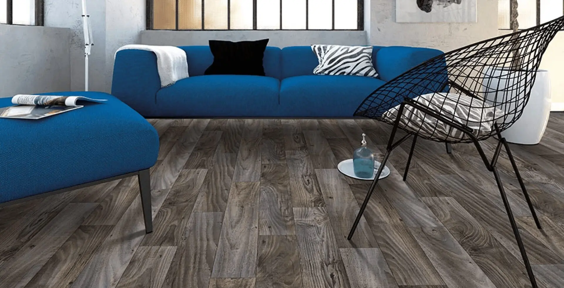 A living room with blue furniture and wood floors.